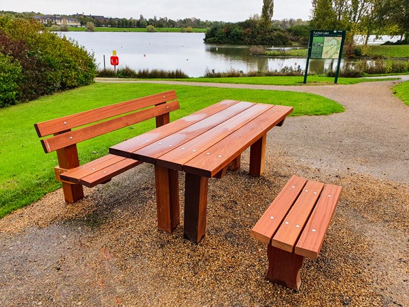 A picnic bench with Furzton Lake in the background.